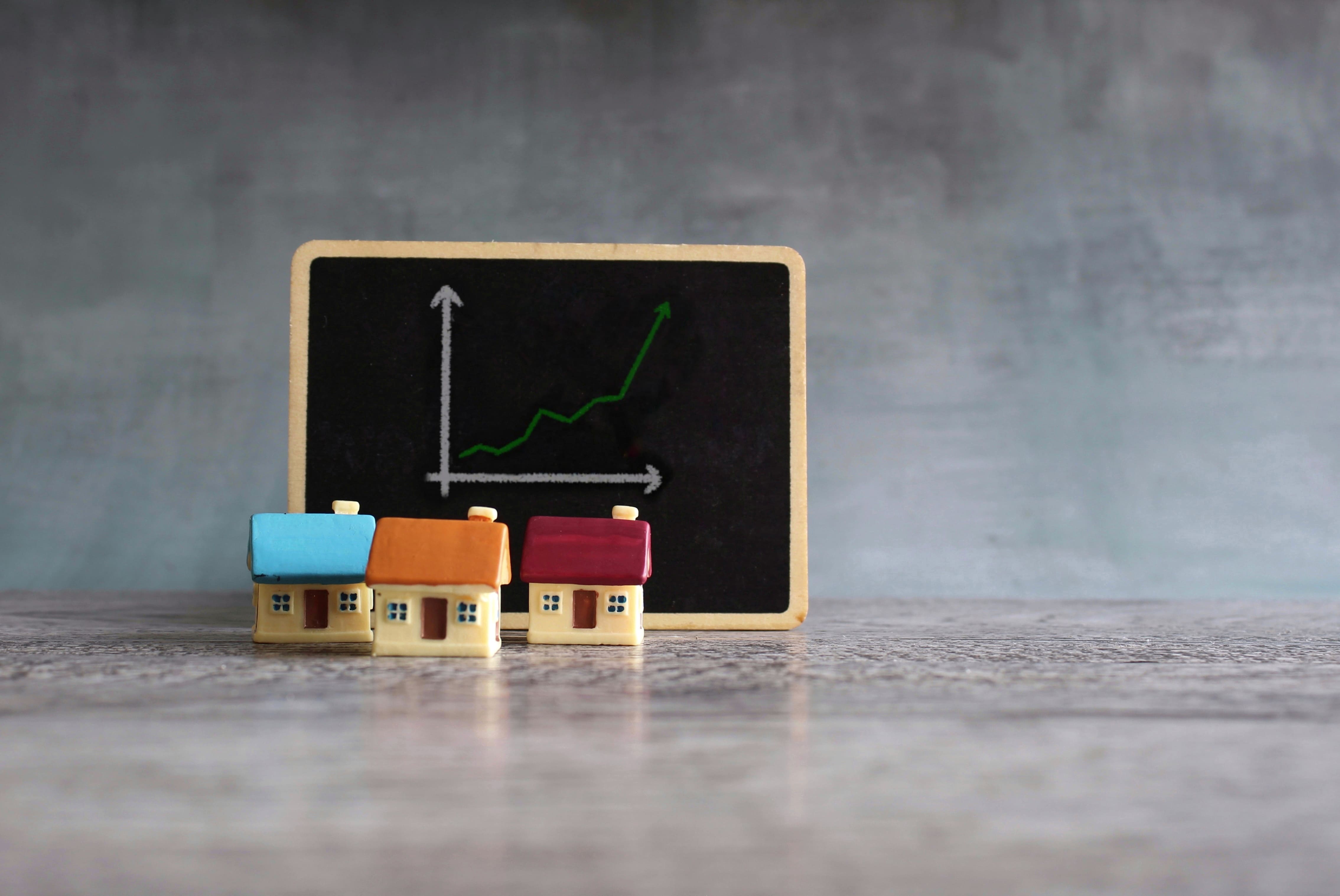 House model with profit arrow representing real estate home sales growth