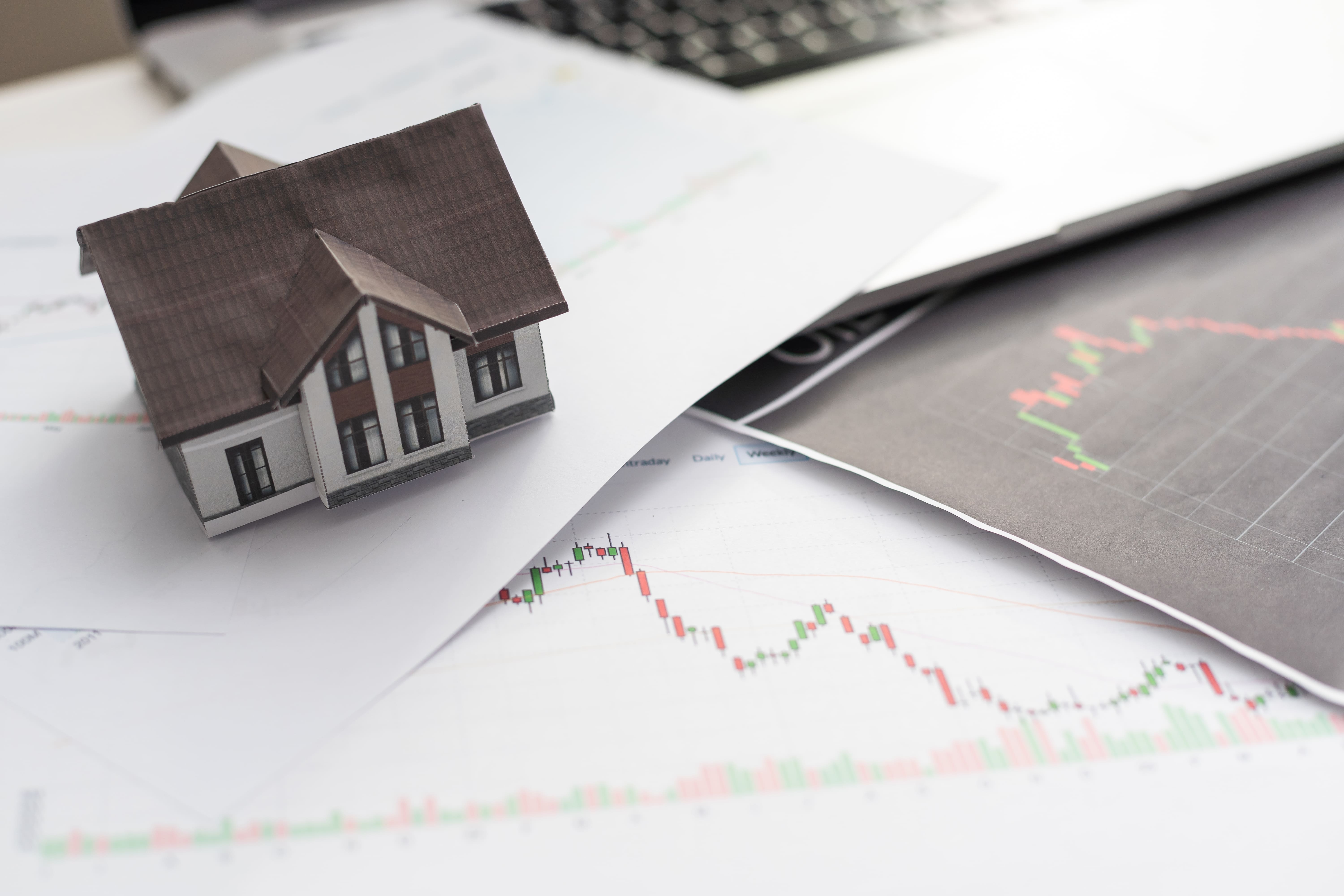 Red upward arrow over house models showing home value appreciation trends