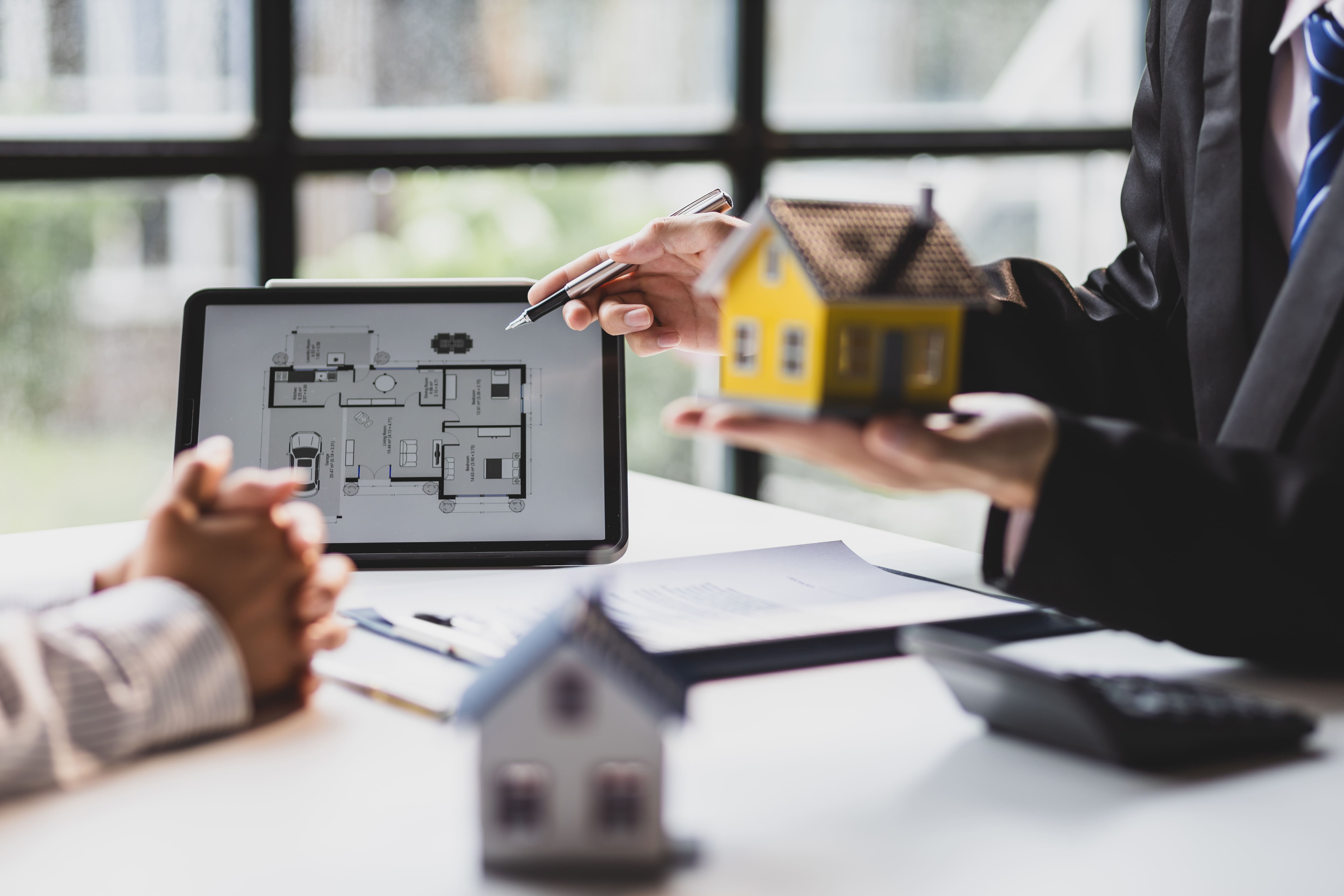 Real estate agent offering property keys to a client after a transaction