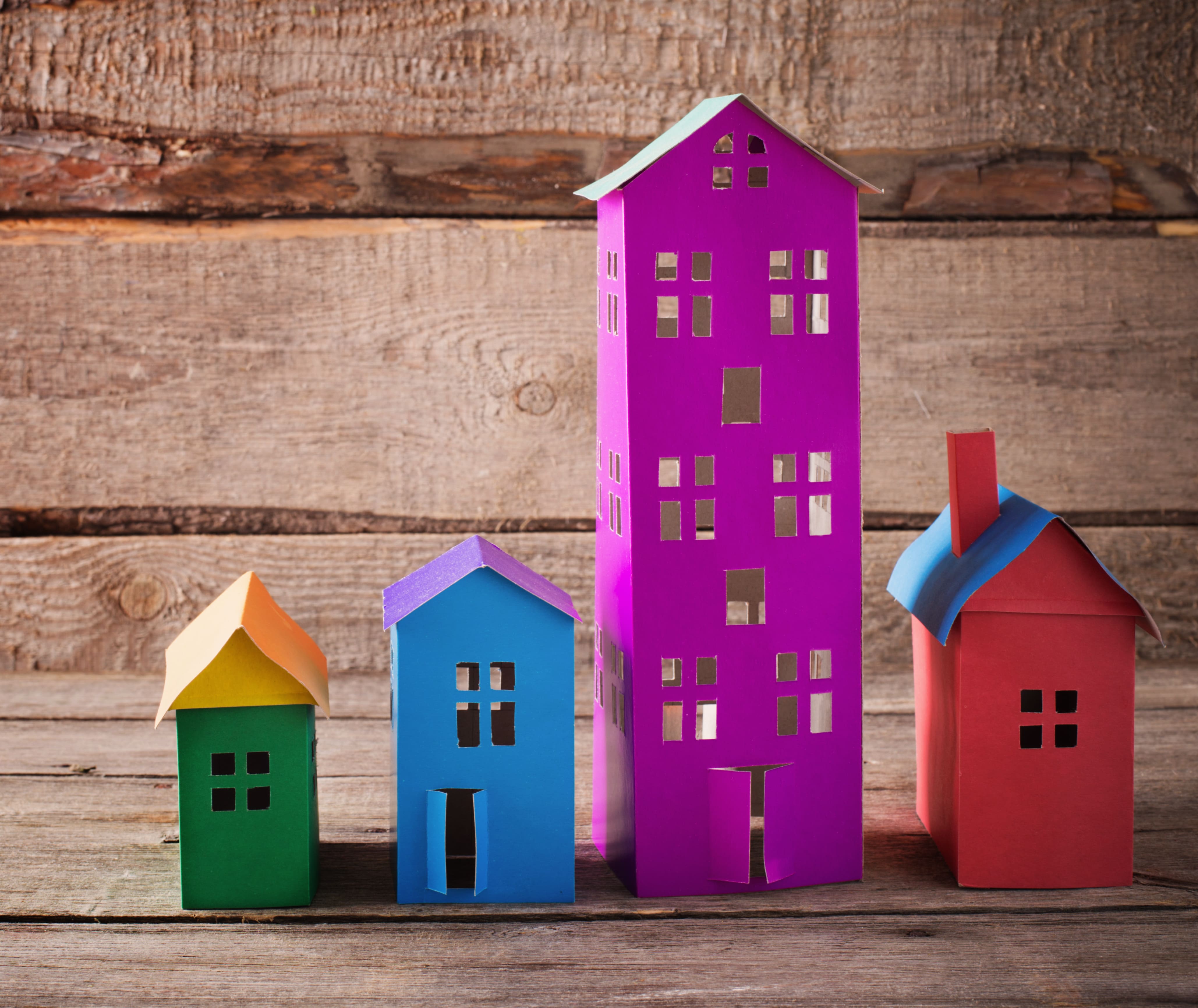 Colorful paper house models representing diverse housing market property types