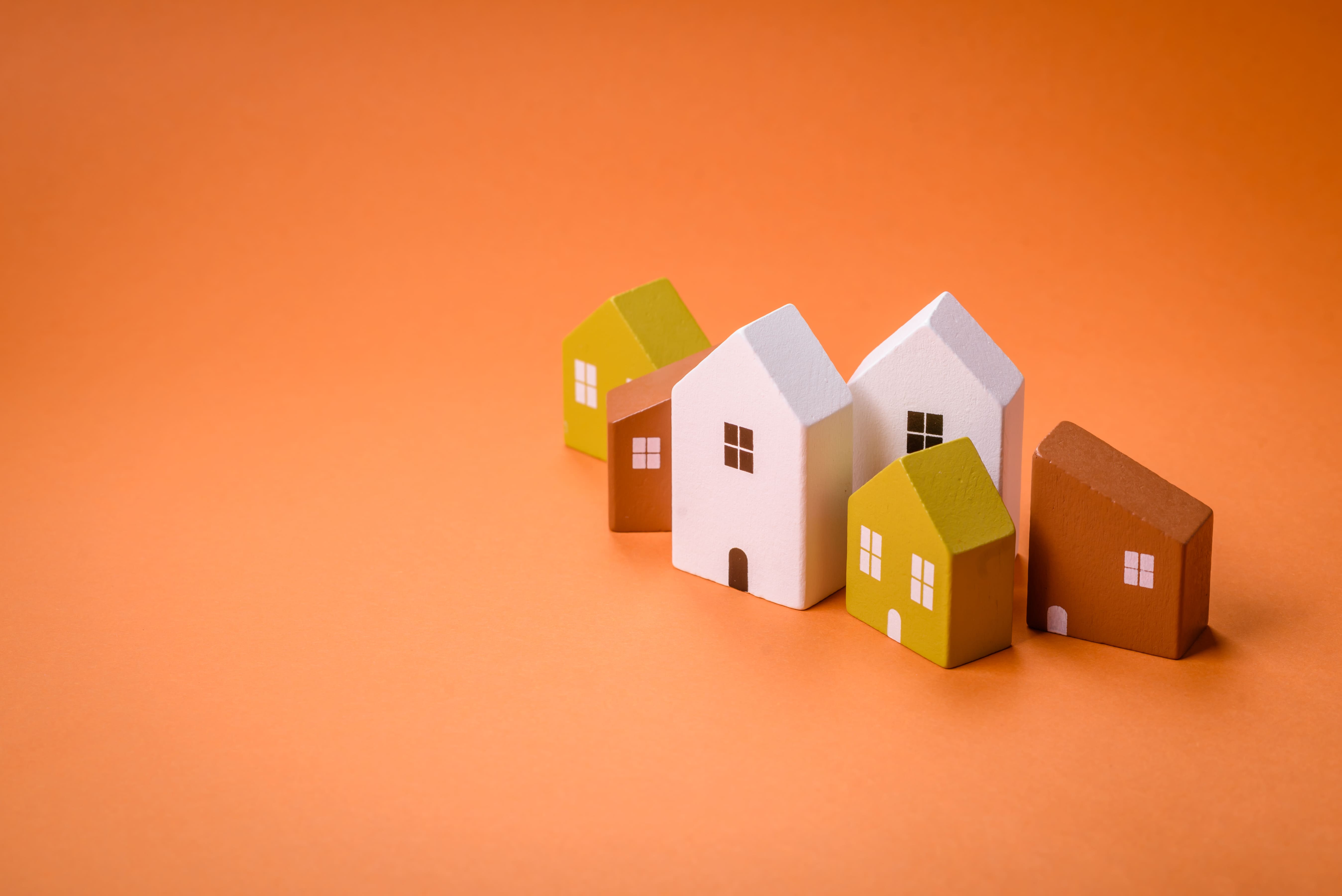 Colorful miniature houses representing diverse property types in the housing market