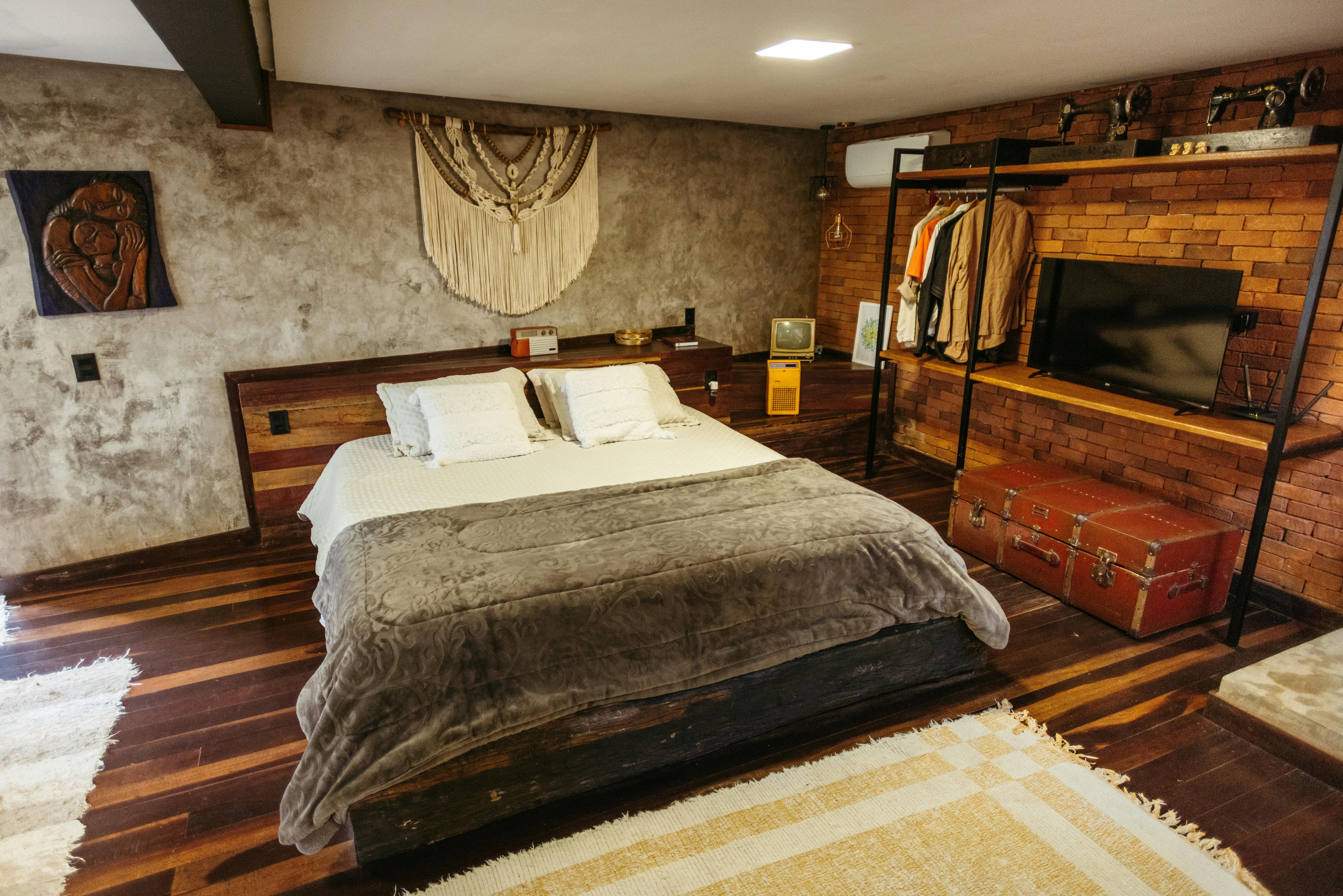 STR cabin master bedroom with brick accent wall and open wardrobe rack